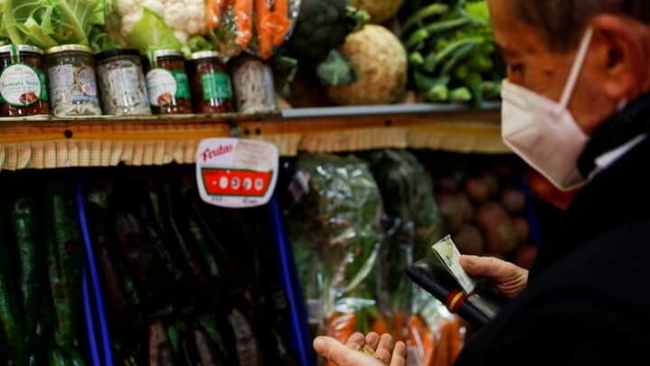 Man pays for groceries at a local market in Madrid