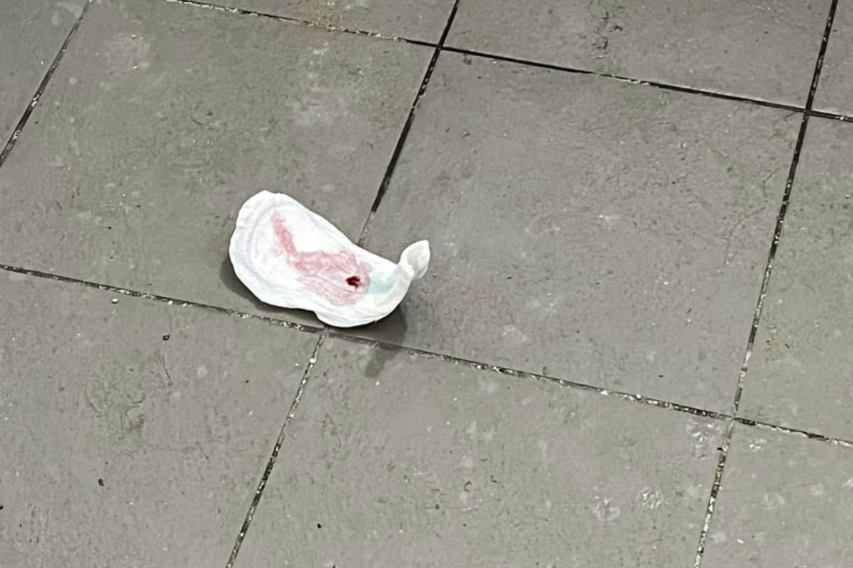 Une serviette hygiénique usagée laissée sur la plage